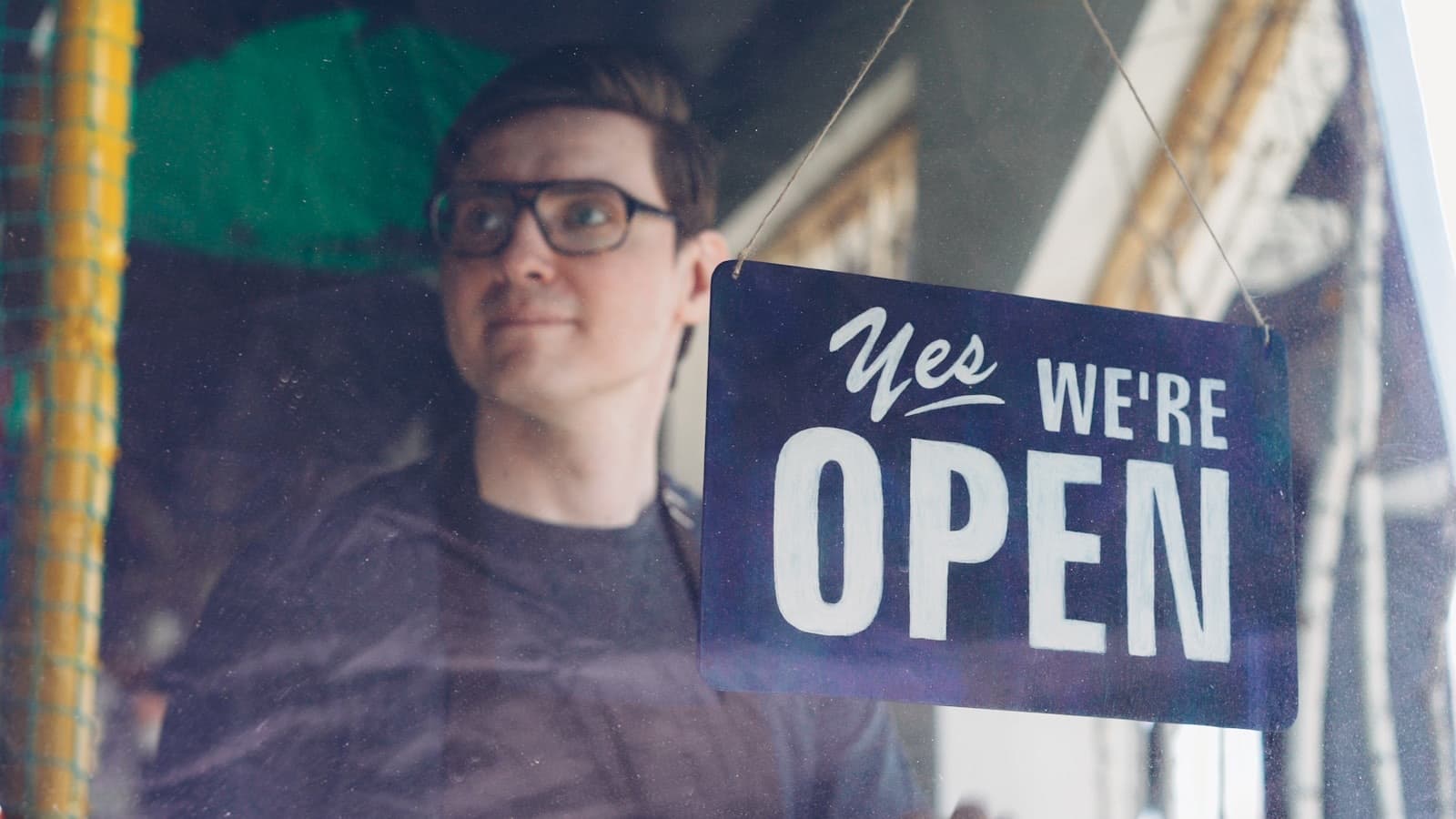 A new owner turning the shop sign to open after buying the business
