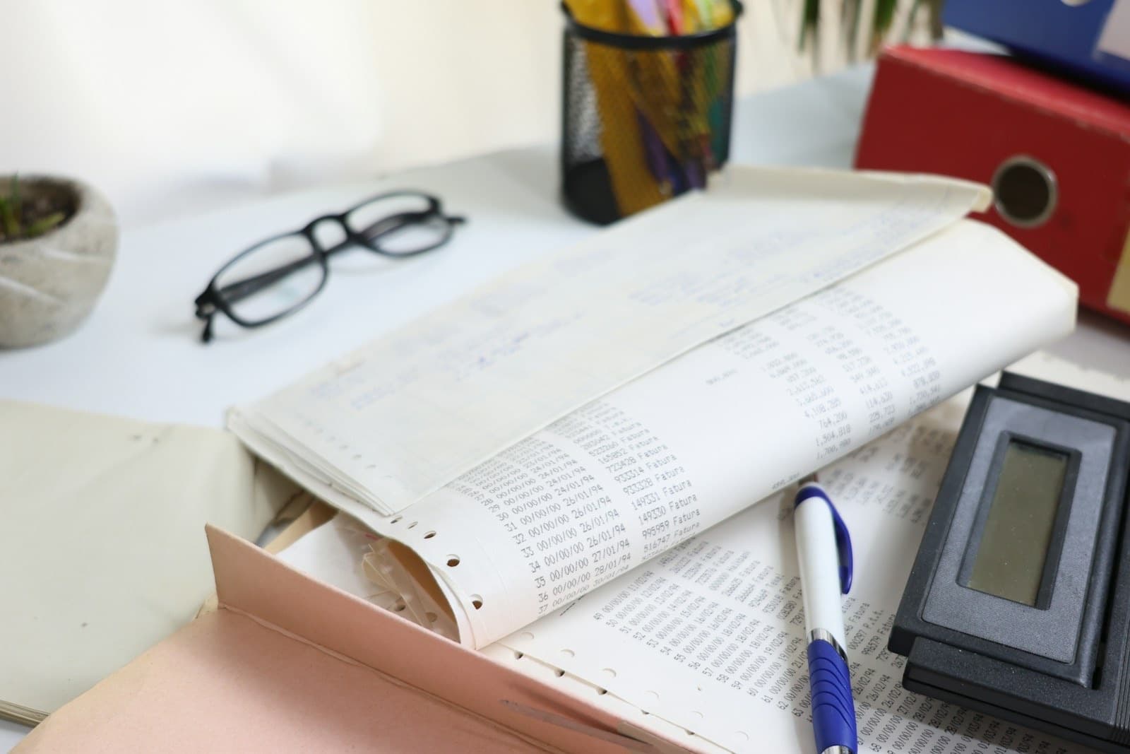 Accounts, ledgers and a calculator on a desk at tax time